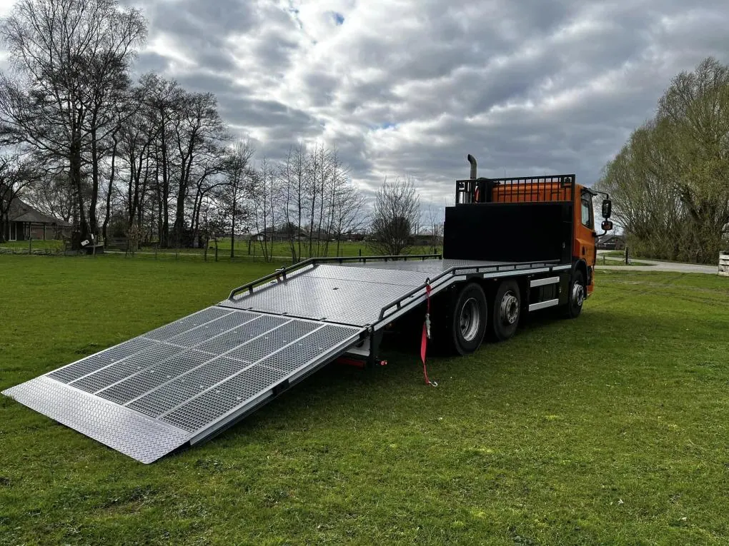 Oprijklep machine-transportwagen voorzien van zwaarlastroosters