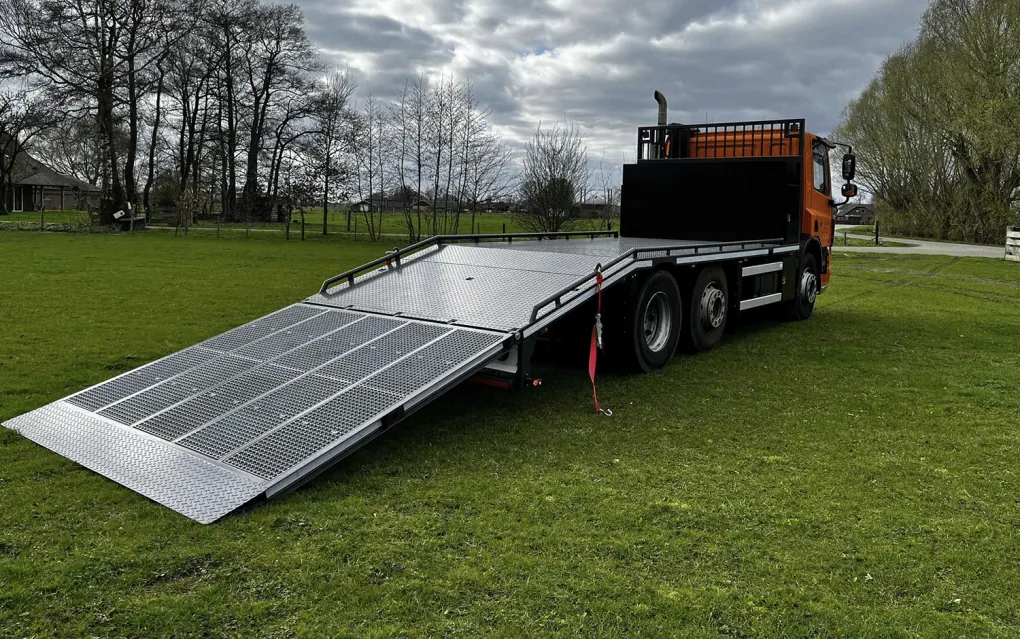 Oprijklep machine-transportwagen voorzien van zwaarlastroosters